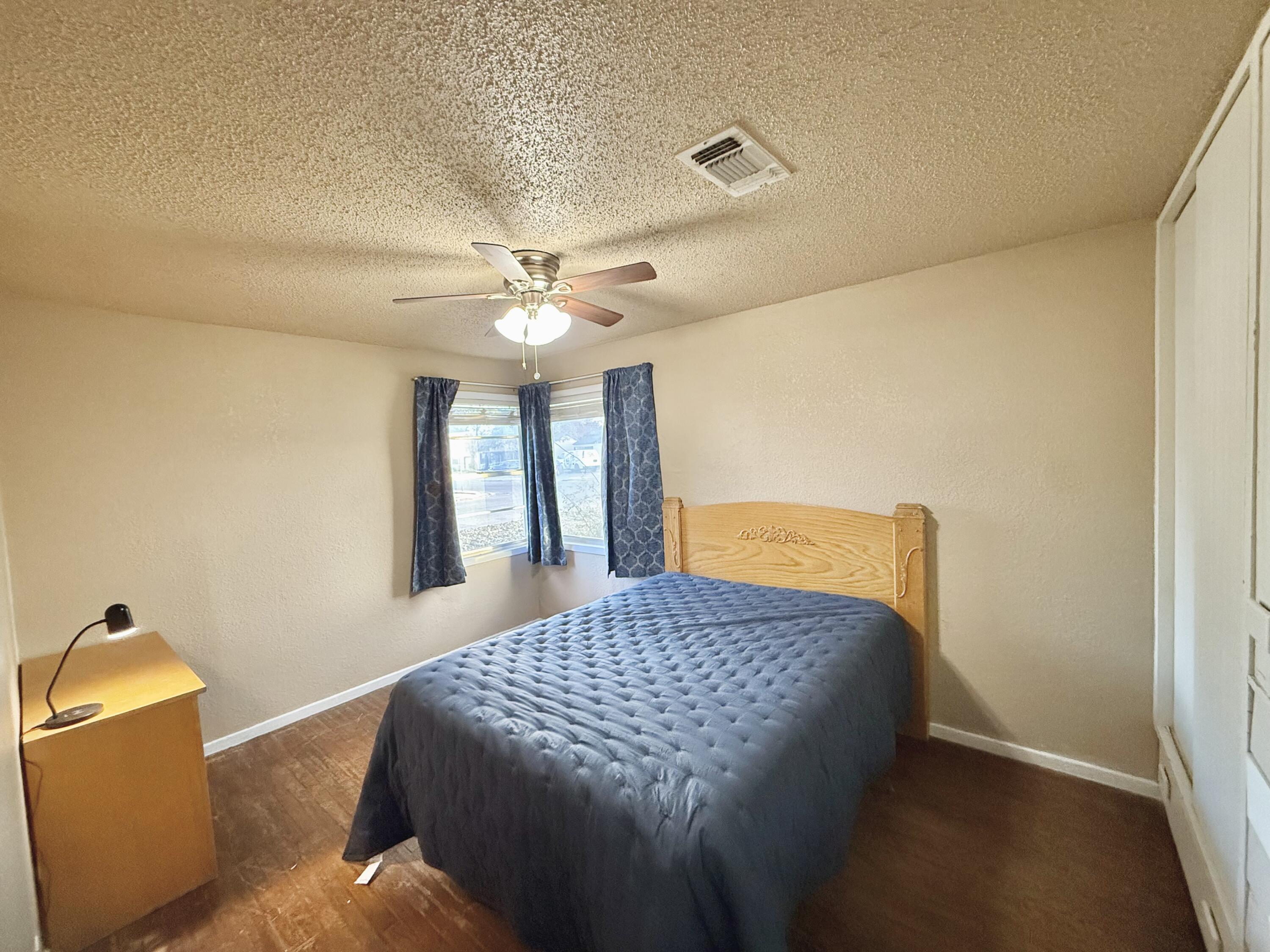 3602 31st Street Lubbock, TX 79410 - Photo 28 of 33 a bedroom with a bed and a chandelier