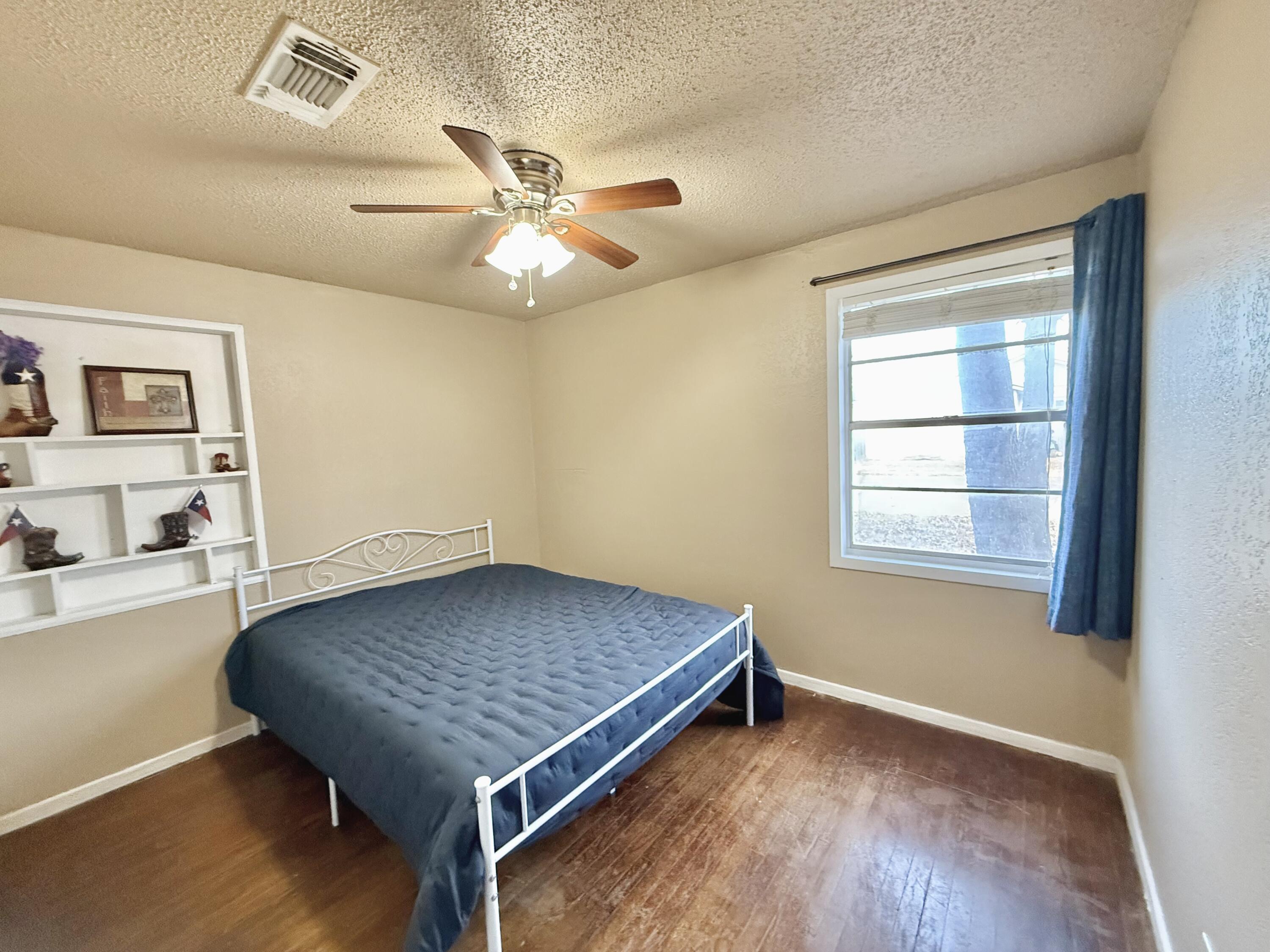 3602 31st Street Lubbock, TX 79410 - Photo 31 of 33 a room with a wooden floor and ceiling fan