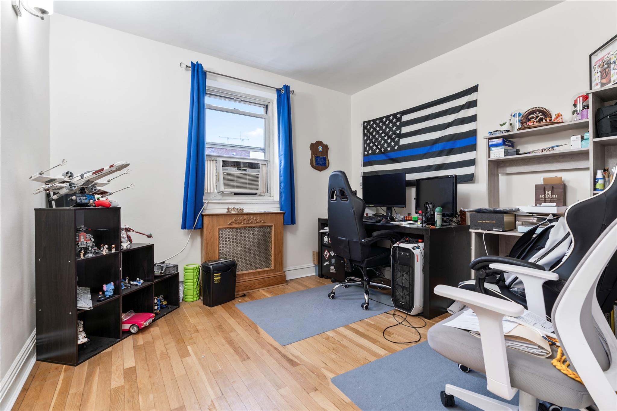 88-12 151st Avenue, Unit 4B Queens, NY 11414 - Photo 13 of 17 a room with furniture a chandelier and a flat screen tv