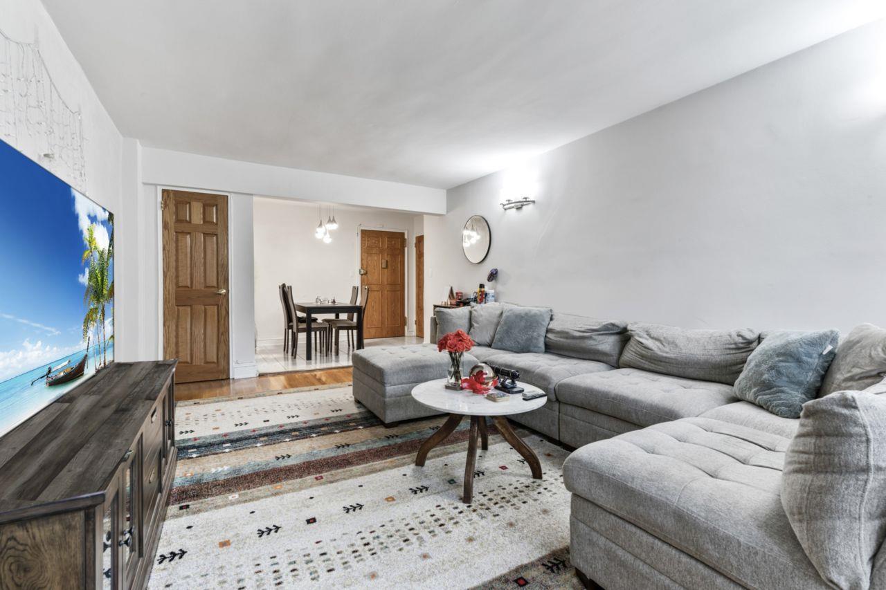 88-12 151st Avenue, Unit 4B Queens, NY 11414 - Photo 7 of 17 a living room with furniture and a flat screen tv