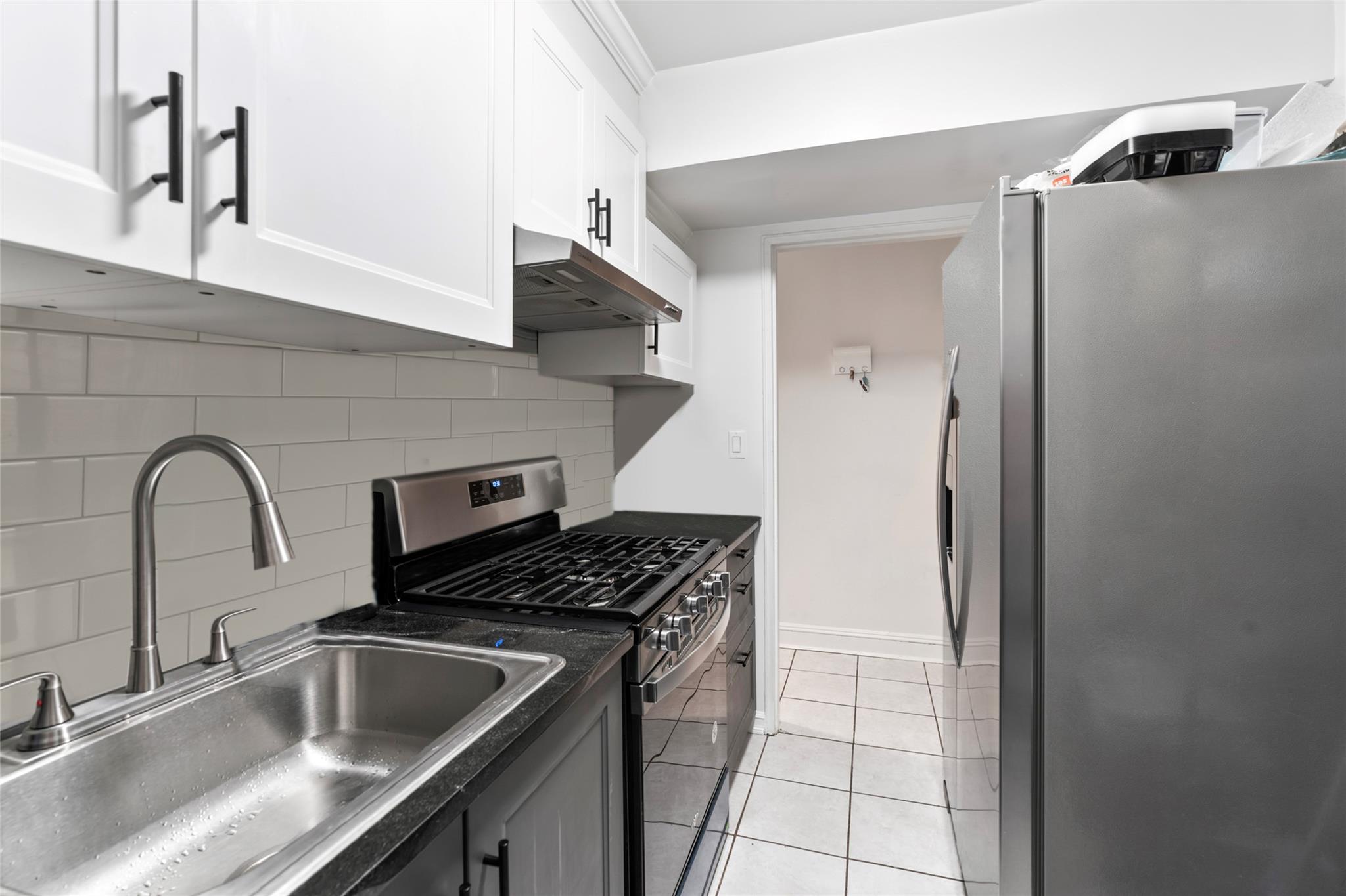 88-12 151st Avenue, Unit 4B Queens, NY 11414 - Photo 8 of 17 a kitchen with a sink and a refrigerator