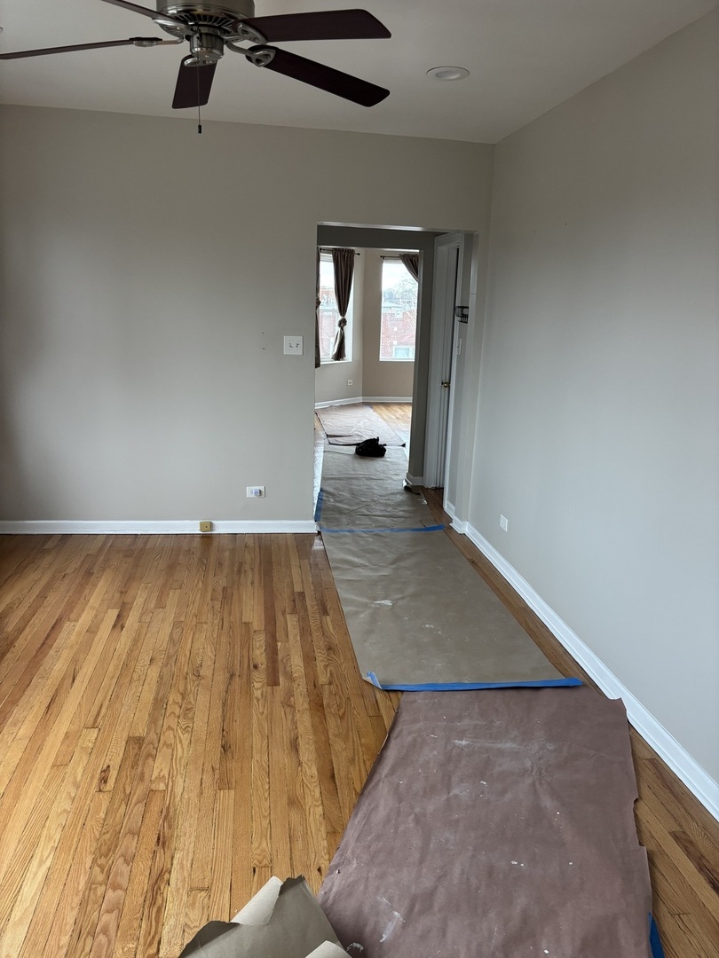 8052 South Aberdeen Street, Unit 3 Chicago, IL 60620 - Photo 2 of 6 an empty room with wooden floor and windows