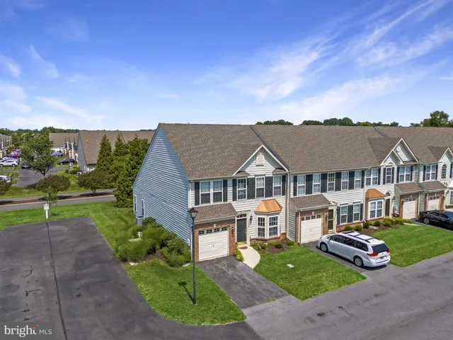 a view of a big house with a big yard and potted plants