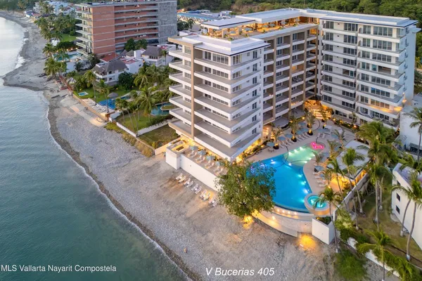 a front view of a multi story residential apartment building with yard