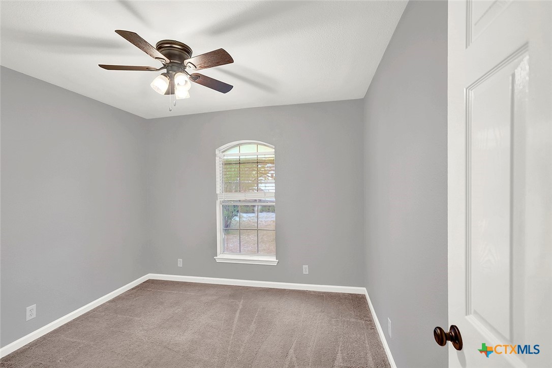 140 Riley Cove Kyle, TX 78640 - Photo 21 of 26 an empty room with windows and fan