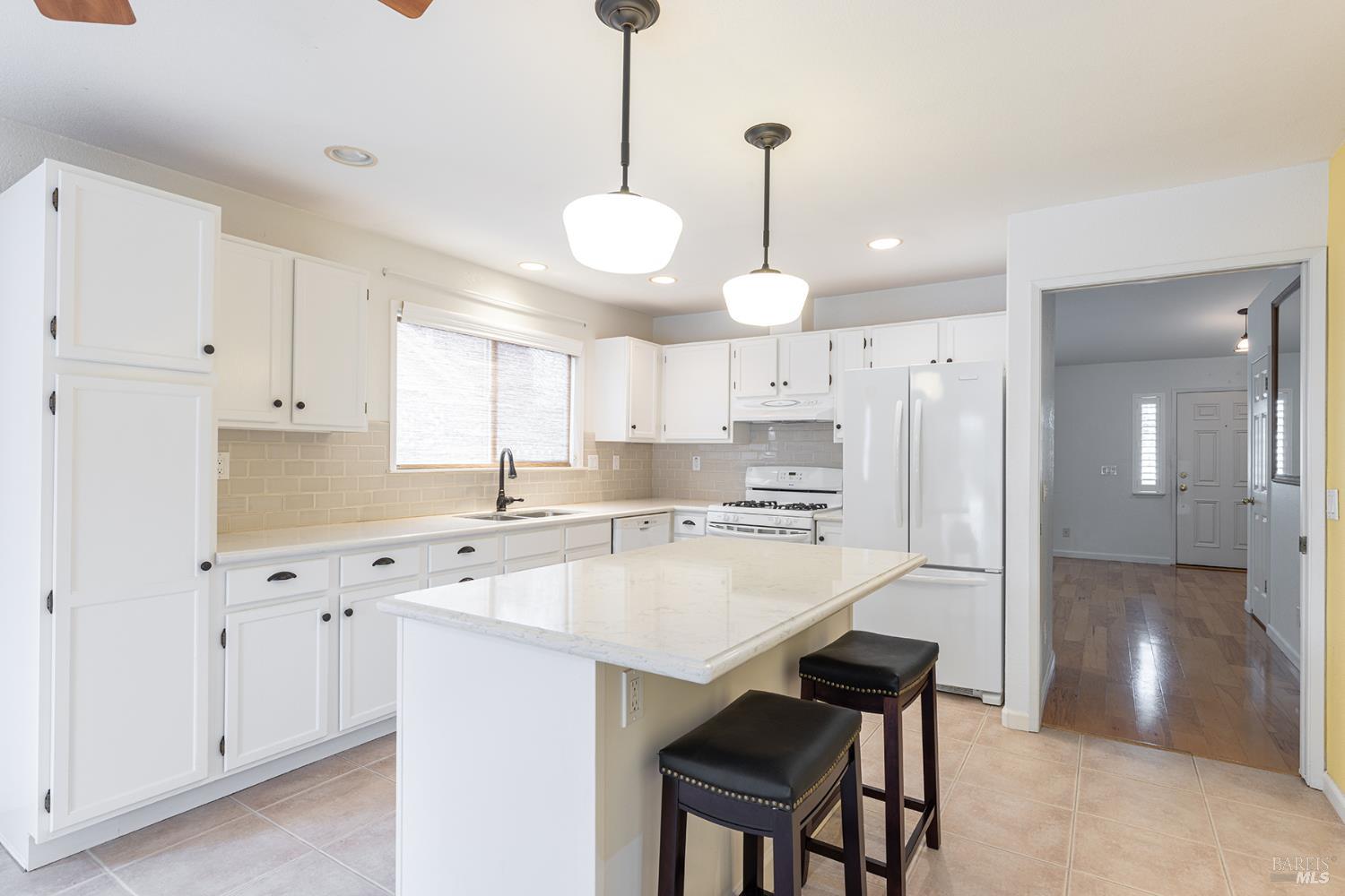 349 Sugar Maple Lane Windsor, CA 95492 - Photo 15 of 47 a kitchen with kitchen island granite countertop a sink a center island and cabinets