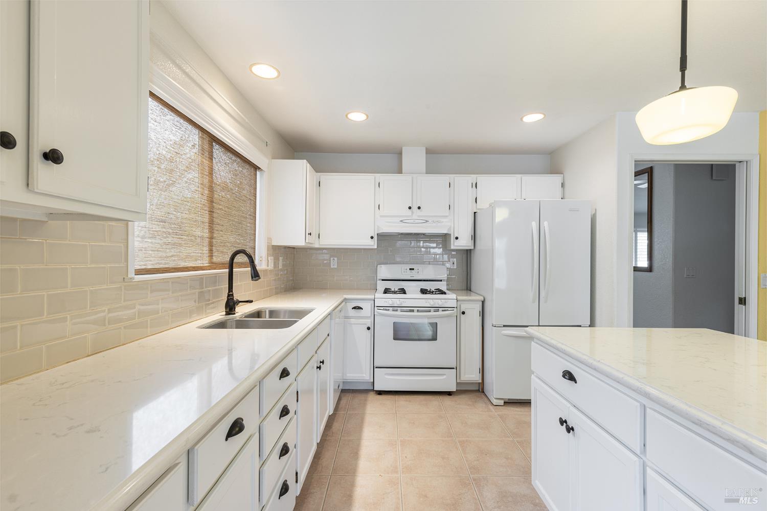 349 Sugar Maple Lane Windsor, CA 95492 - Photo 18 of 47 a kitchen with white cabinets and white appliances