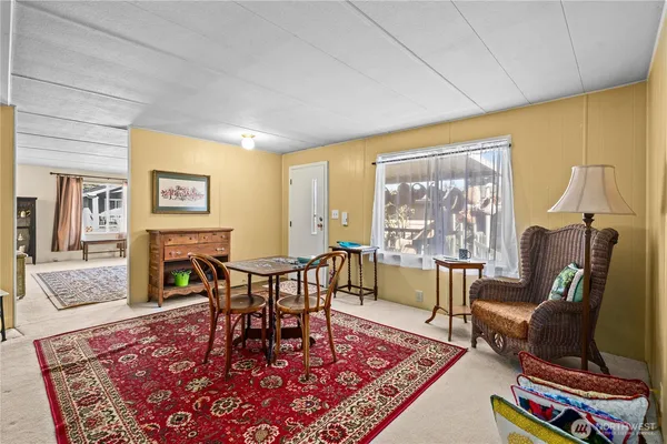 a living room with furniture a rug and a floor to ceiling window