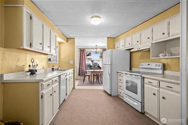 a kitchen with white cabinets and white appliances