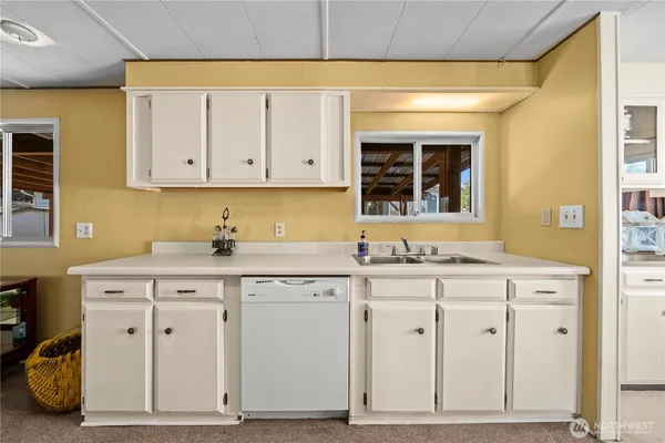 a kitchen with cabinets appliances a sink and a window
