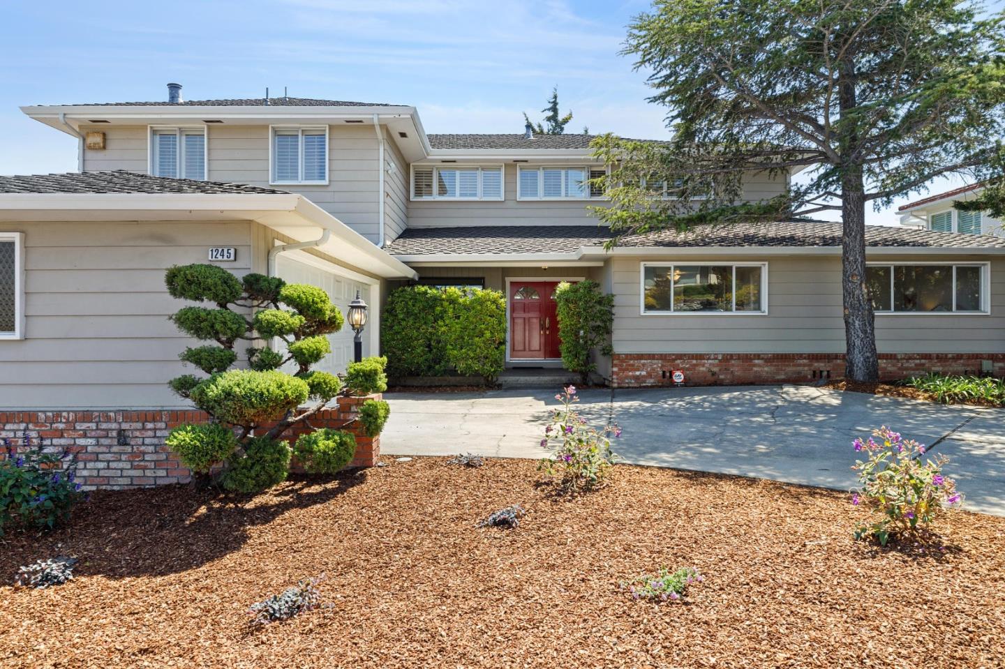 1245 Encina Drive Millbrae, CA 94030 - Photo 3 of 100 a front view of a house with a yard and a glass top table