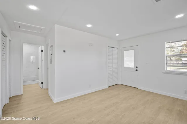a view of an empty room with a kitchen