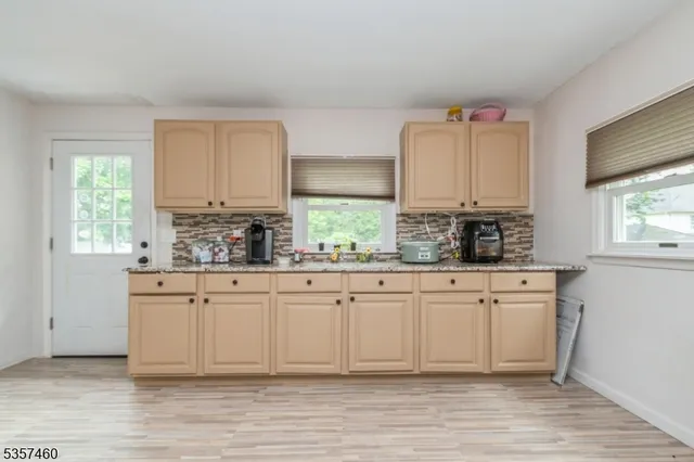 a kitchen with stainless steel appliances granite countertop a stove a sink cabinets and a window