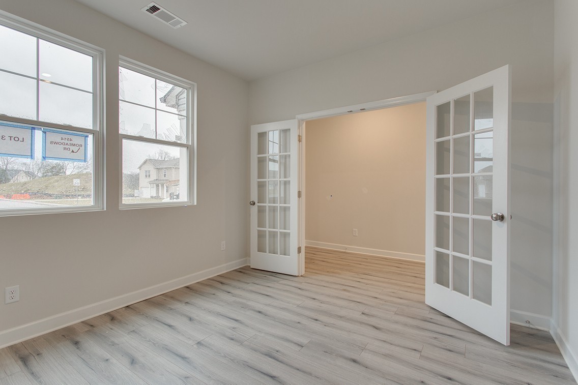 1310 Kristopher Drive Lebanon, TN 37087 - Photo 7 of 36 an empty room with wooden floor and windows
