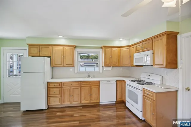 a kitchen with a sink a stove a refrigerator and white cabinets