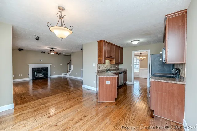 a large kitchen with stainless steel appliances granite countertop a refrigerator a stove oven a sink with island and chairs