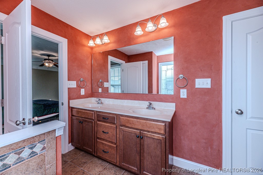 255 Trenton Place Cameron, NC 28326 - Photo 24 of 49 a bathroom with a granite countertop sink a mirror and a shower