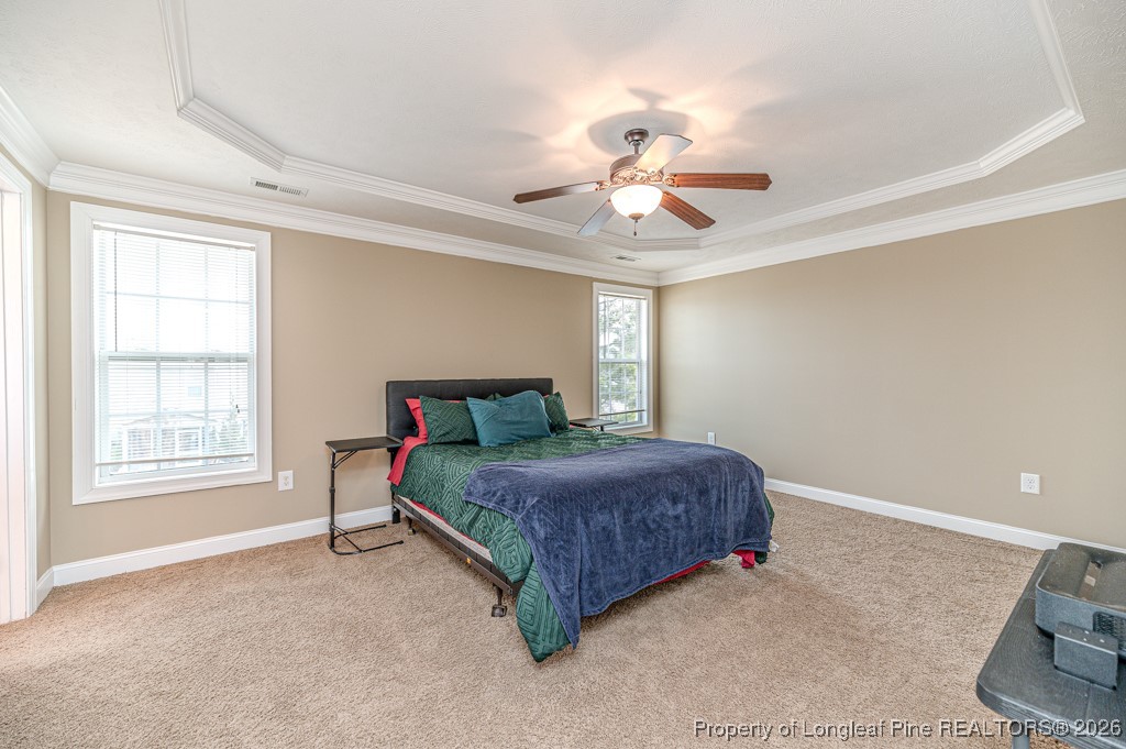 255 Trenton Place Cameron, NC 28326 - Photo 30 of 49 a spacious bedroom with a bed and a chandelier