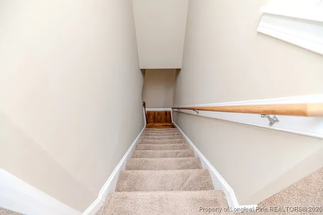 a hallway with stairs and a white door