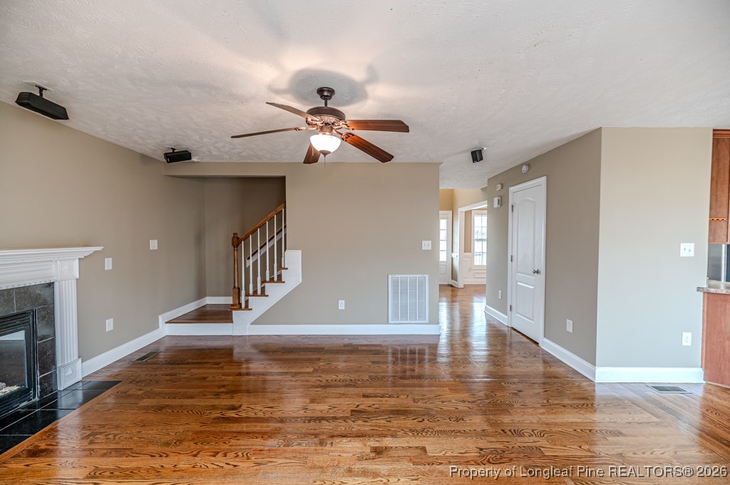 255 Trenton Place Cameron, NC 28326 - Photo 40 of 49 a view of an empty room with chandelier fan and wooden floor