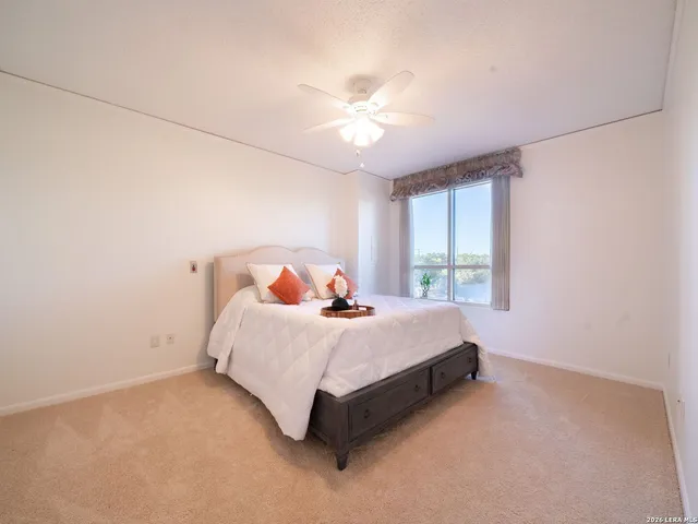 a bed sitting in a spacious bedroom next to a window