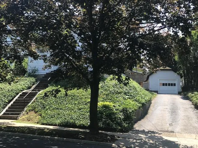 a front view of a house with a yard garage and outdoor seating