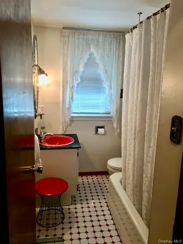 a bathroom with a toilet and shower curtain