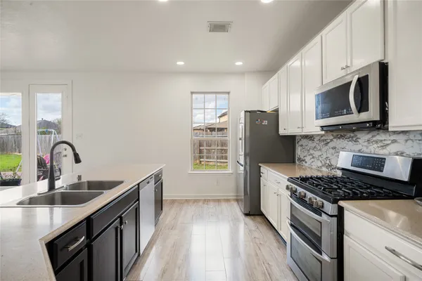a kitchen with stainless steel appliances granite countertop a sink stove and refrigerator