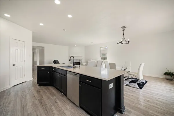 a kitchen with a sink appliances and wooden floor
