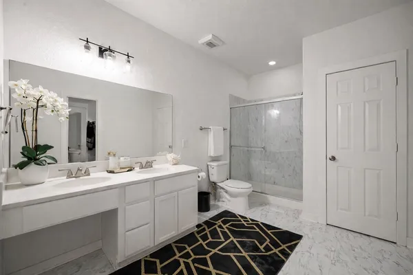 a bathroom with a double vanity sink mirror and toilet
