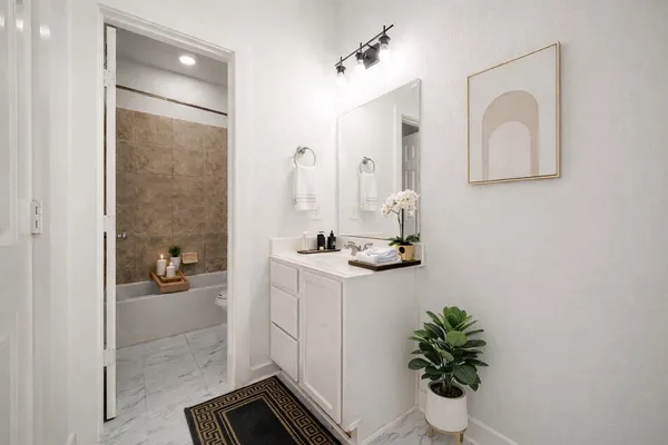 a bathroom with a sink a potted plant and a mirror