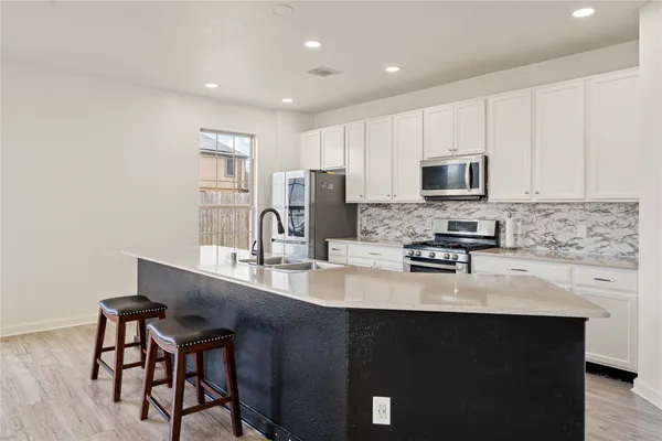 a kitchen with appliances a sink cabinets and wooden floor