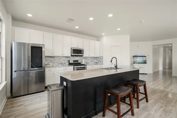 a kitchen with stainless steel appliances a sink stove and refrigerator