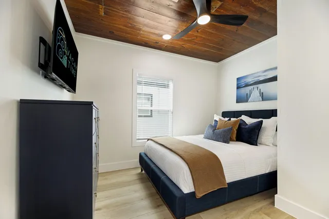 a bedroom with a bed mirror and window