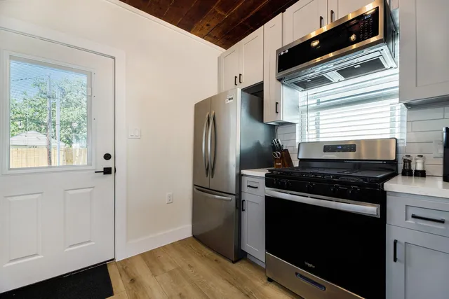 a kitchen with stainless steel appliances granite countertop a refrigerator and a stove top oven