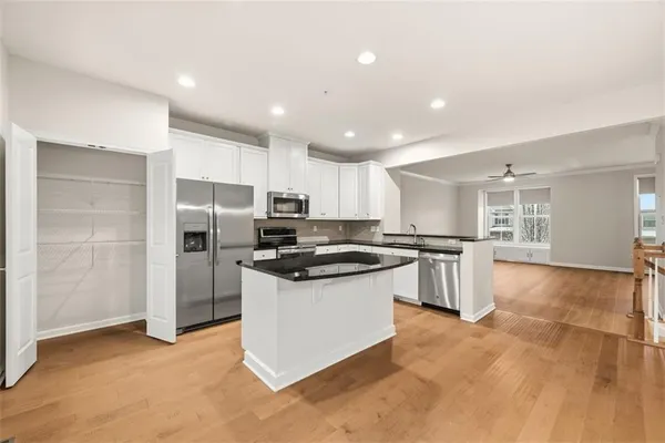 a kitchen with stainless steel appliances kitchen island granite countertop a refrigerator and a stove top oven
