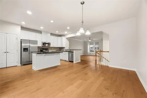 a view of kitchen with stainless steel appliances kitchen island granite countertop a refrigerator a stove oven a sink with island and chairs