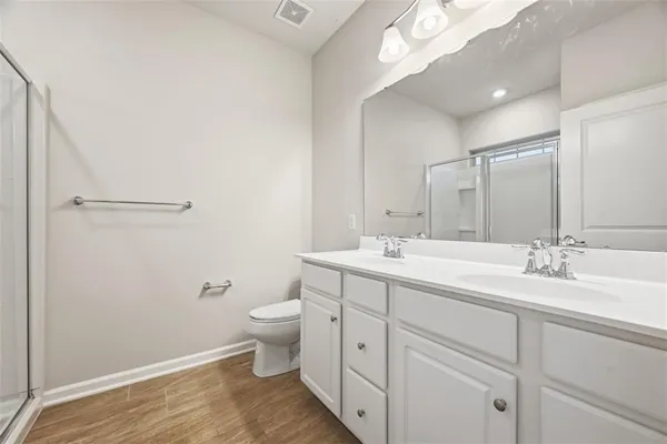 a bathroom with a double vanity sink toilet and a mirror