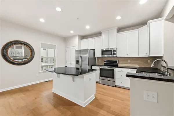 a kitchen with stainless steel appliances granite countertop a stove a sink and a refrigerator