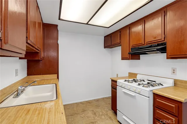 a kitchen with granite countertop a sink and a stove top oven