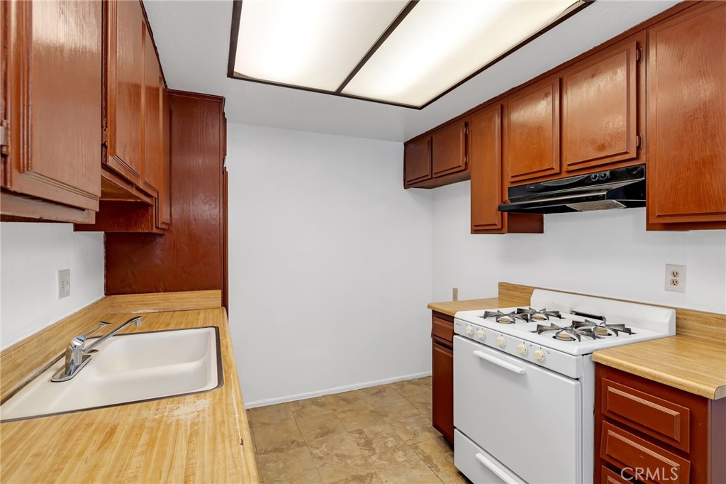 1629 West Ball Road Anaheim, CA 92802 - Photo 12 of 21 a kitchen with stainless steel appliances granite countertop a sink stove and refrigerator