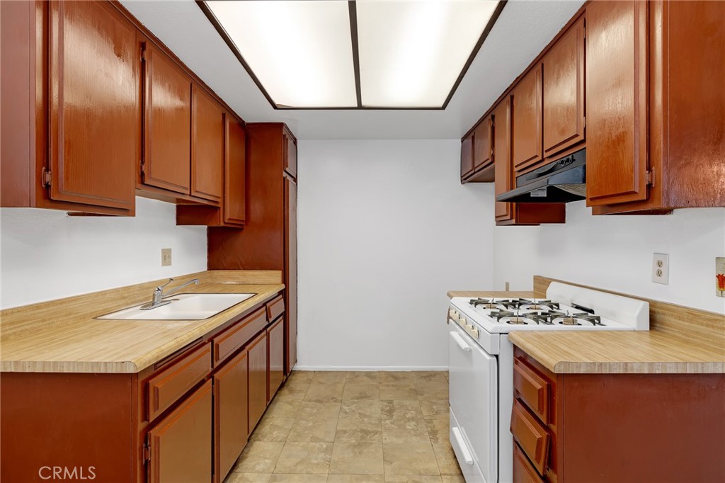 1629 West Ball Road Anaheim, CA 92802 - Photo 9 of 21 a kitchen with stainless steel appliances granite countertop a sink a stove and a wooden floors