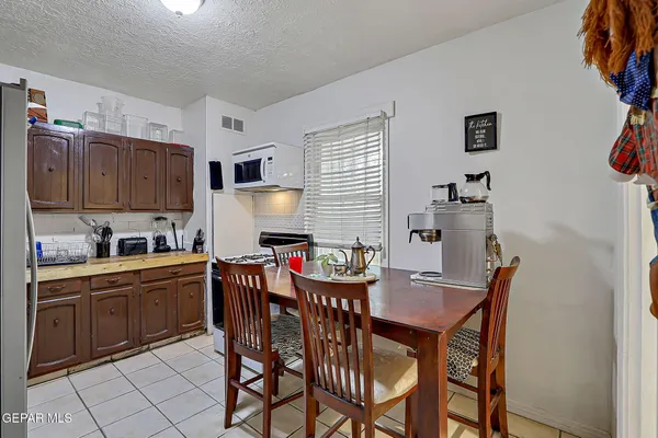 a kitchen with granite countertop a dining table chairs and white appliances