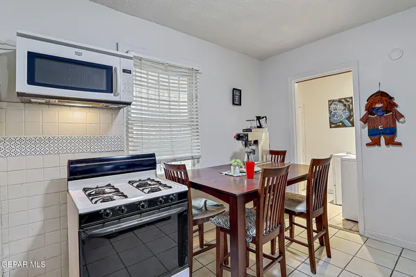 a kitchen with stainless steel appliances a stove a table and chairs in it