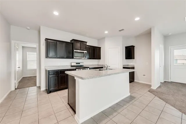 a kitchen with stainless steel appliances granite countertop a sink stove and cabinets