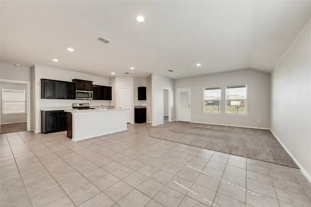 a view of a kitchen with a sink dishwasher oven a fireplace and a window