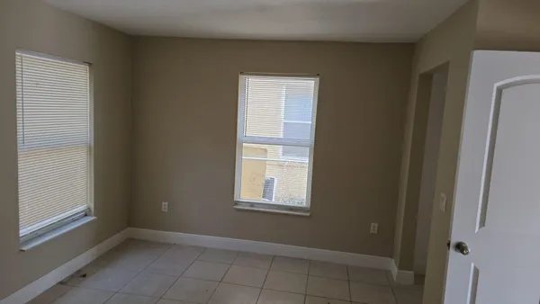 a view of an empty room with closet and a window