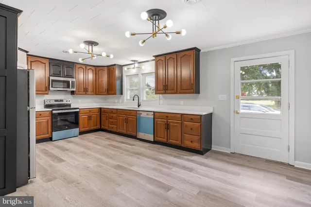 a kitchen with stainless steel appliances kitchen island a large counter top a sink and a refrigerator