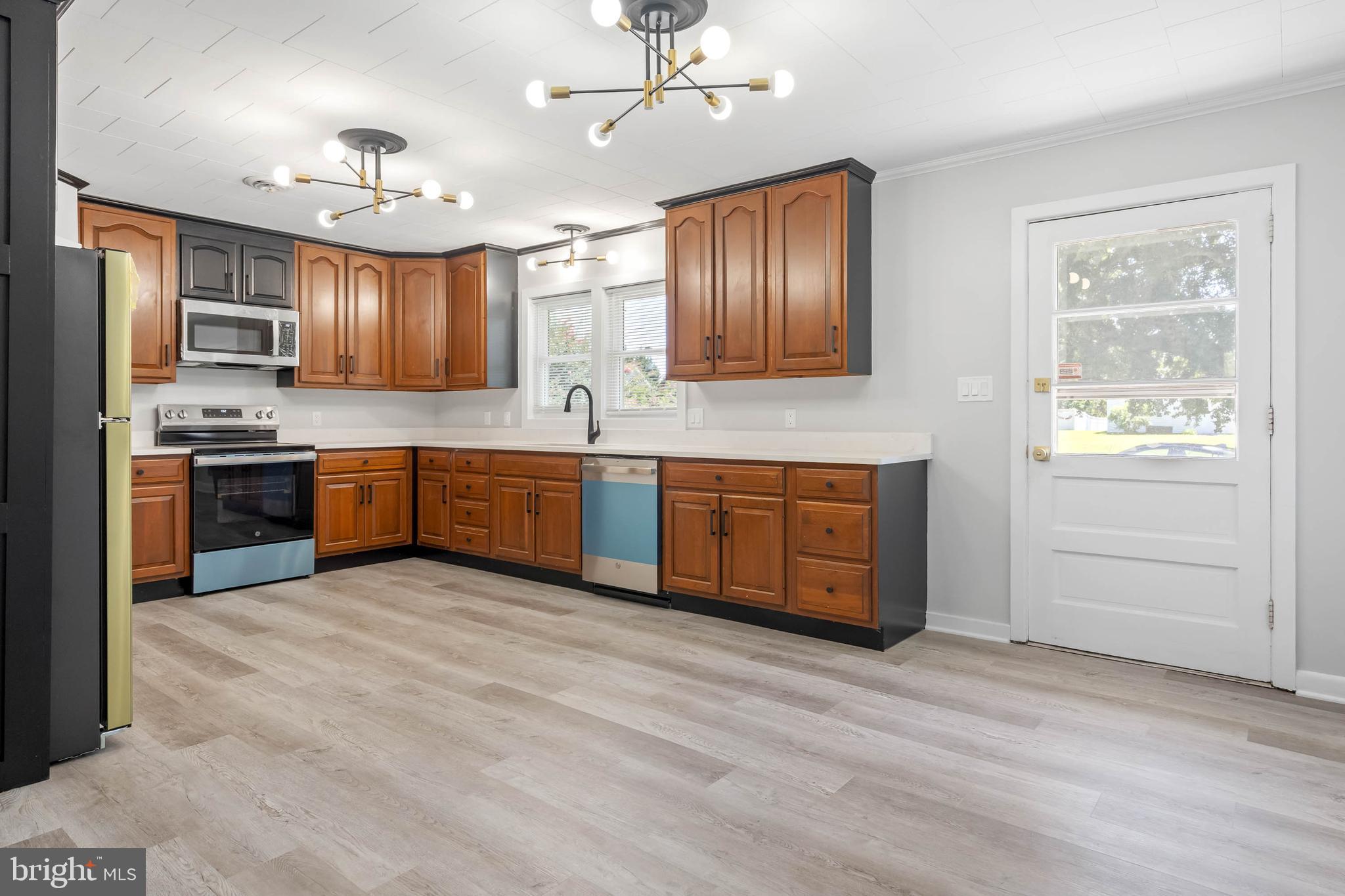 34132 Clay Road Lewes, DE 19958 - Photo 13 of 32 a large kitchen with wooden floors and stainless steel appliances