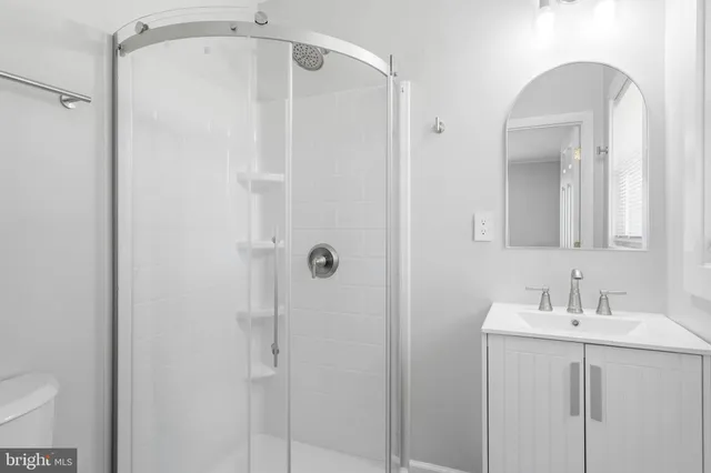 a bathroom with a shower a sink and mirror
